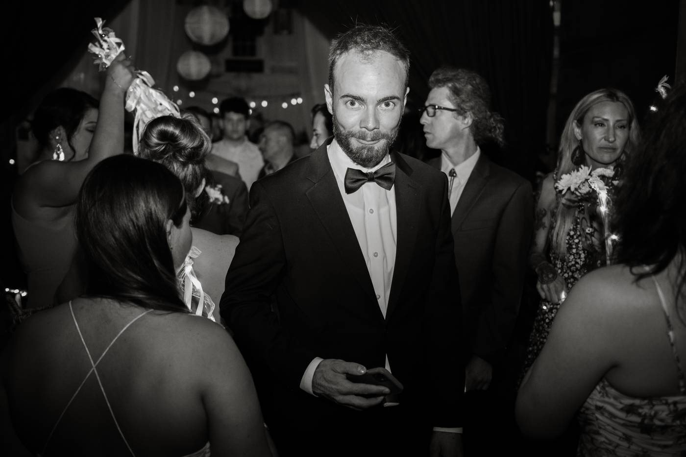 Man in a tuxedo looks at the camera at a formal event