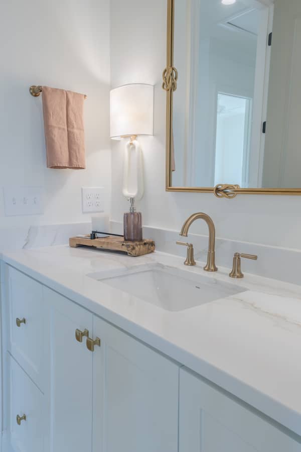 Modern bathroom vanity with white marble countertop and brass fixtures
