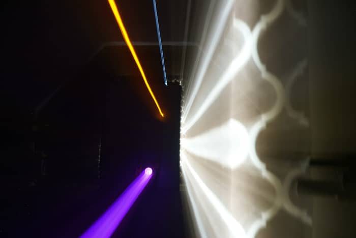 Abstract light streaks of purple, orange, and blue against a dark background with patterned light