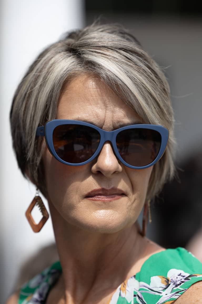 Woman with sunglasses and floral dress at an outdoor event