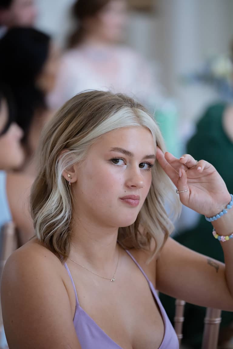 Young woman with blonde hair and light makeup at a wedding reception