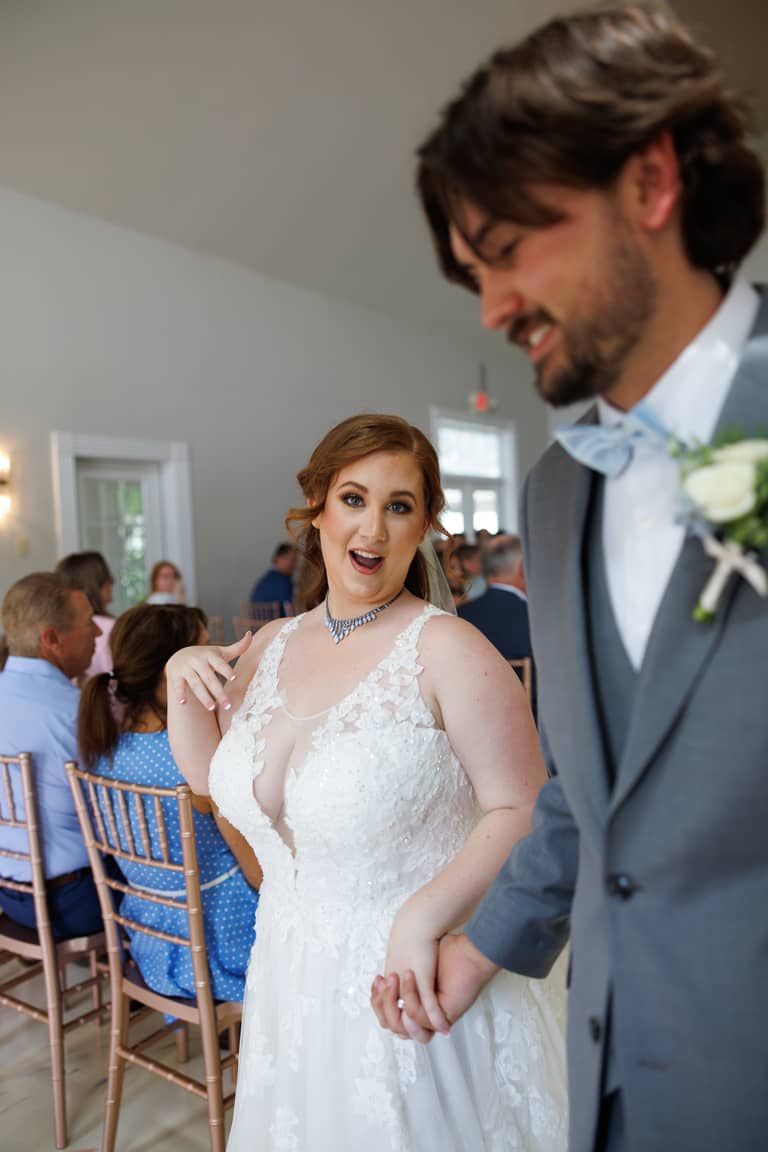 Surprised bride and groom hold hands during their wedding reception indoors